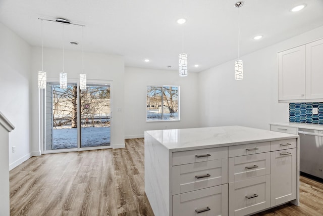 kitchen featuring pendant lighting, a center island, dishwasher, and tasteful backsplash