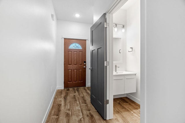 doorway featuring sink and light hardwood / wood-style flooring