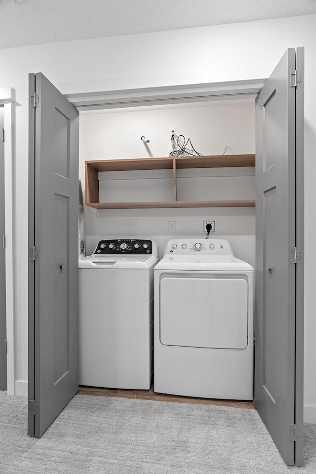 washroom featuring separate washer and dryer and a textured ceiling