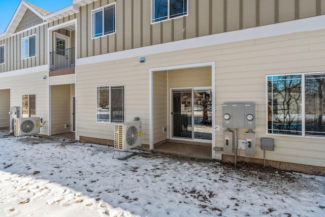 snow covered house featuring ac unit