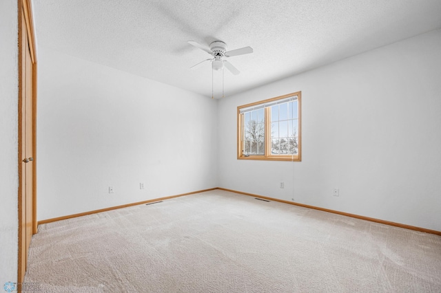 carpeted empty room featuring a textured ceiling and ceiling fan