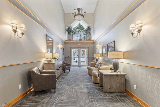 living area featuring a notable chandelier, french doors, and a high ceiling