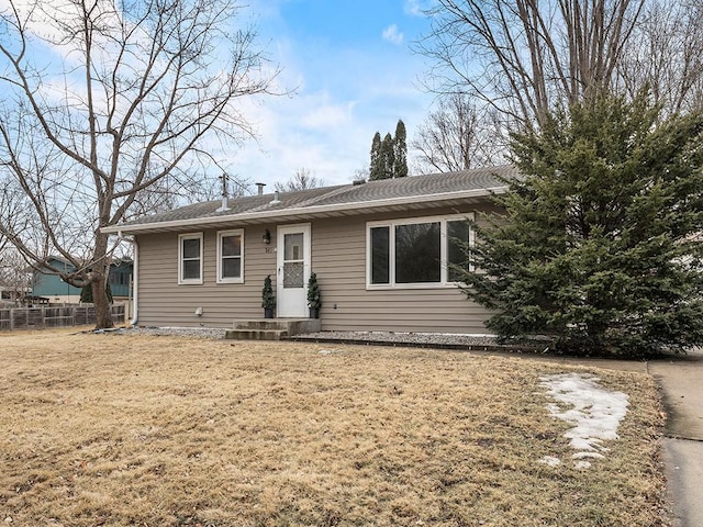 ranch-style home featuring a front yard and fence