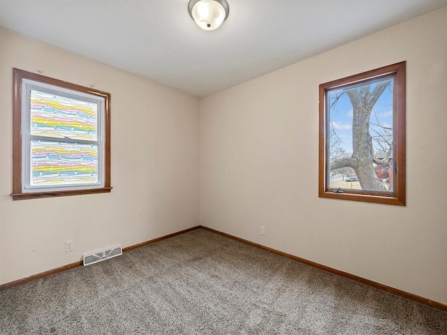 carpeted empty room with visible vents and baseboards