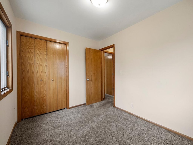 unfurnished bedroom featuring a closet, carpet flooring, and baseboards