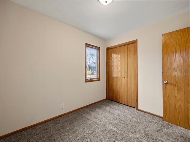 unfurnished bedroom featuring carpet, baseboards, and a closet