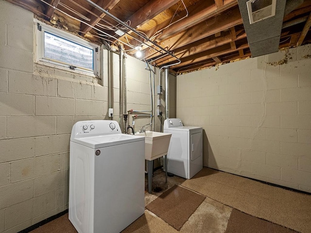 laundry room with laundry area, independent washer and dryer, a sink, and visible vents