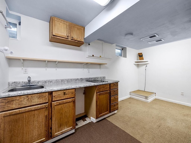 kitchen featuring carpet floors, brown cabinets, a sink, and open shelves