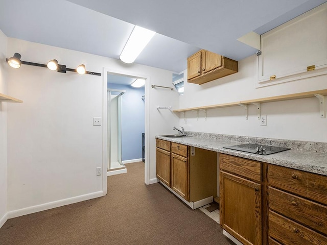 kitchen with open shelves, light countertops, a sink, baseboards, and black electric cooktop