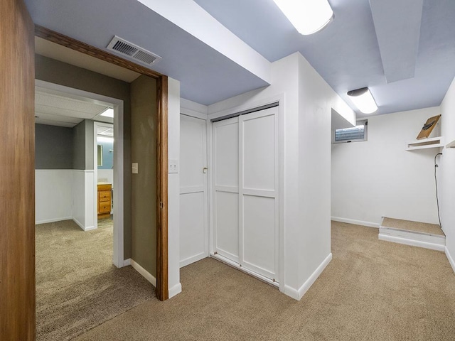 hallway with carpet flooring, visible vents, and baseboards