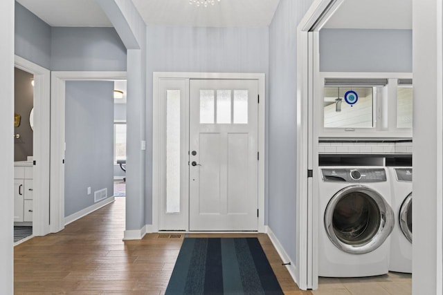 laundry area with washer and clothes dryer and hardwood / wood-style floors