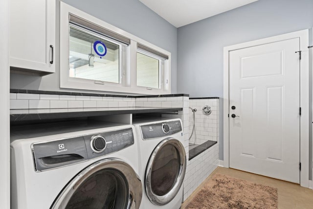 laundry room featuring cabinets and washer and clothes dryer