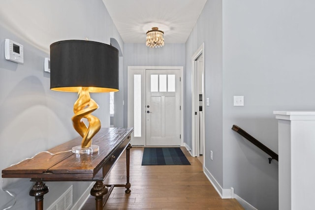 entrance foyer with hardwood / wood-style flooring and a notable chandelier