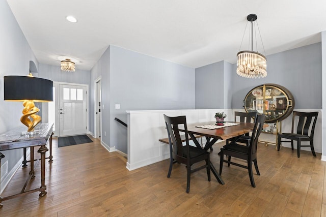 dining room with hardwood / wood-style floors and a chandelier