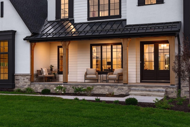 entrance to property featuring a yard and french doors