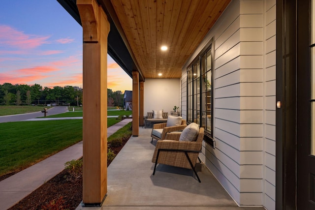 patio terrace at dusk featuring a yard