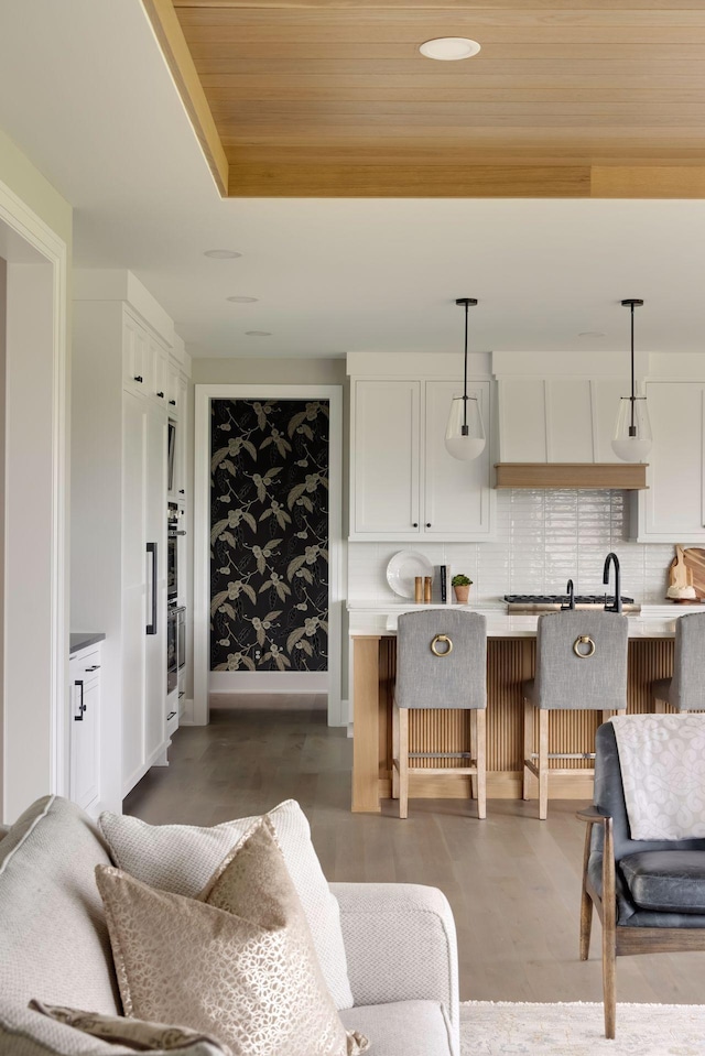 living room featuring hardwood / wood-style floors, wooden ceiling, and a raised ceiling