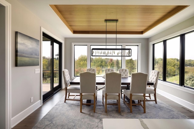 dining area featuring an inviting chandelier, dark hardwood / wood-style floors, wooden ceiling, and a raised ceiling