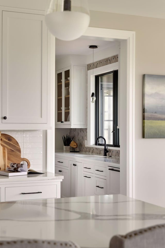 bar with white cabinetry, sink, and decorative backsplash