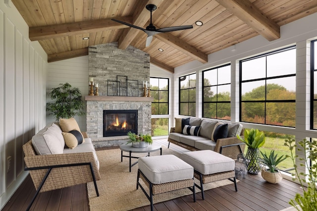 sunroom with ceiling fan, wood ceiling, lofted ceiling with beams, and an outdoor stone fireplace