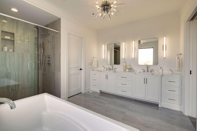 bathroom with vanity, separate shower and tub, and a notable chandelier