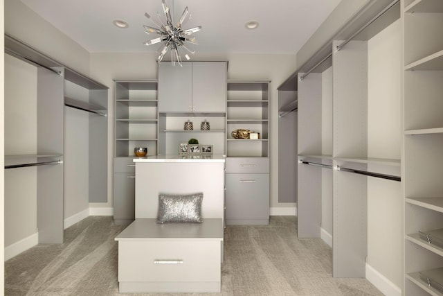 walk in closet featuring light colored carpet and a notable chandelier