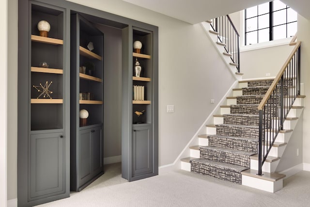 staircase featuring carpet flooring and built in features