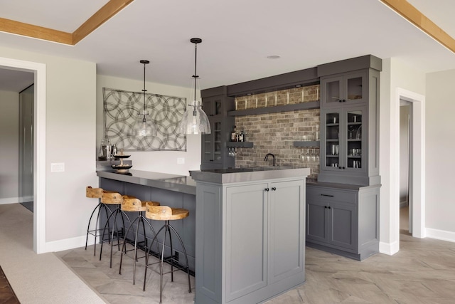 bar with pendant lighting, decorative backsplash, and gray cabinets