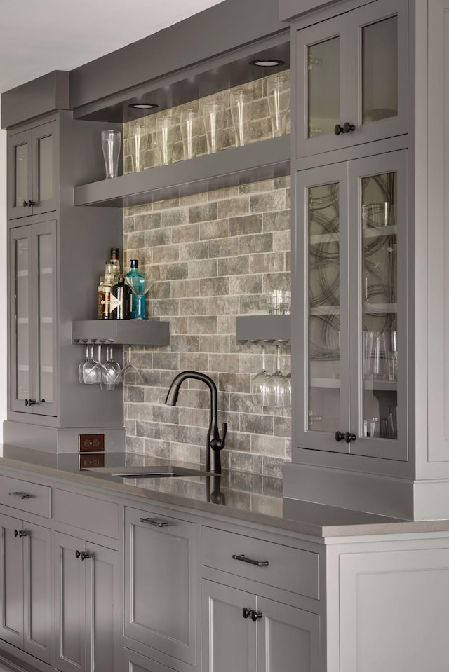 bar featuring sink and backsplash