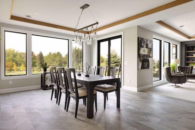 dining space featuring a tray ceiling and a notable chandelier