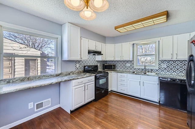 kitchen featuring dark hardwood / wood-style flooring, sink, black appliances, and white cabinets