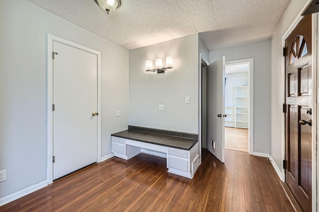 interior space with dark wood-type flooring and a textured ceiling