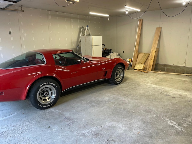 garage with a garage door opener and white fridge