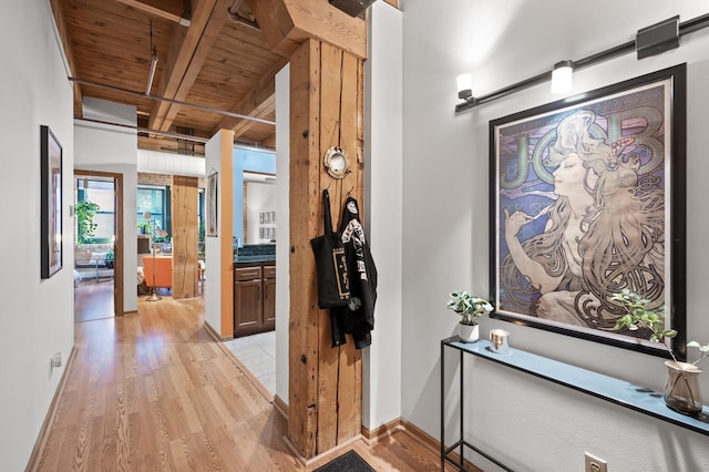 hall with wood ceiling, light hardwood / wood-style flooring, and beamed ceiling