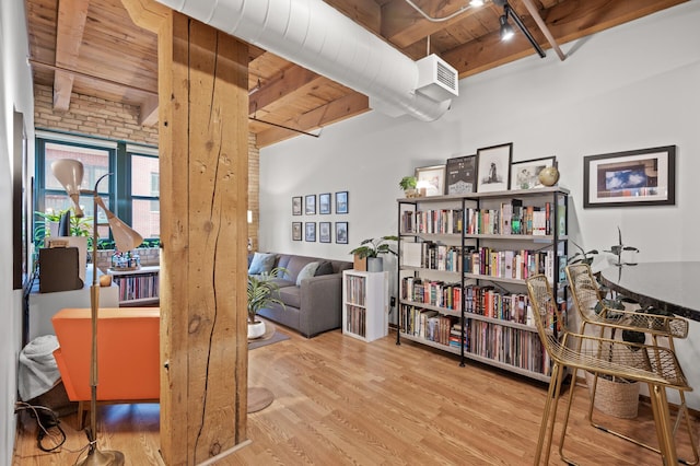 interior space featuring hardwood / wood-style floors, track lighting, wooden ceiling, and beam ceiling