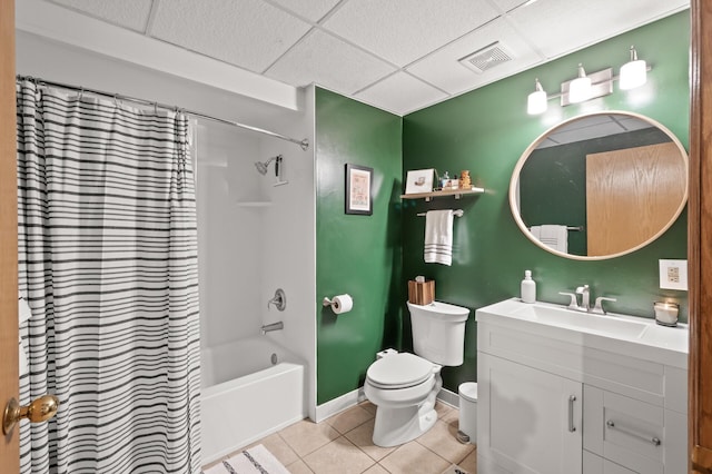 full bathroom featuring shower / tub combo with curtain, tile patterned floors, toilet, vanity, and a drop ceiling