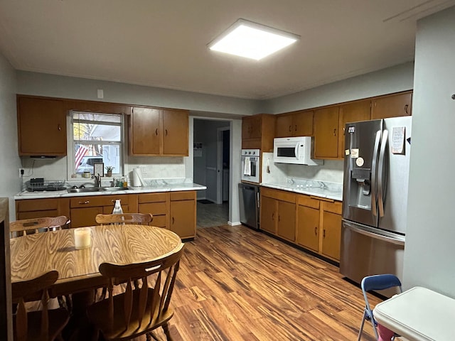 kitchen featuring sink, decorative backsplash, stainless steel appliances, and light hardwood / wood-style floors