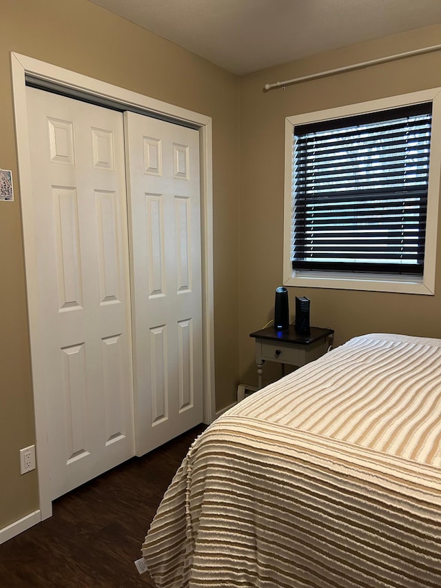 bedroom featuring dark hardwood / wood-style flooring and a closet