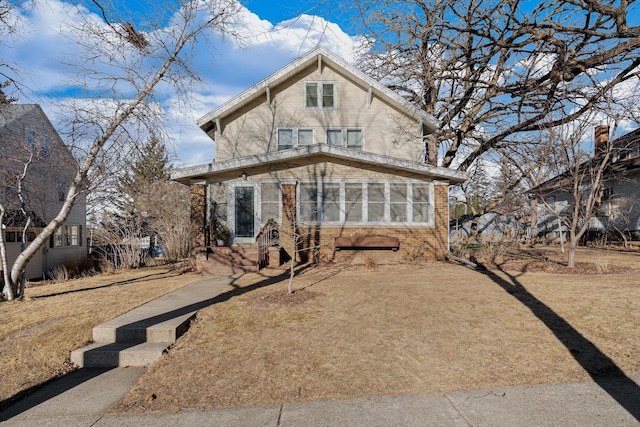 view of front of property featuring a front lawn and a sunroom