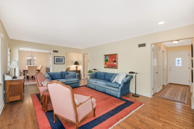 living room with hardwood / wood-style flooring and an inviting chandelier