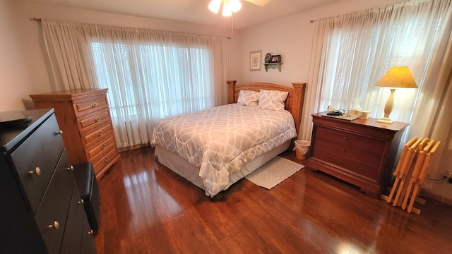 bedroom featuring multiple windows, dark hardwood / wood-style flooring, and ceiling fan