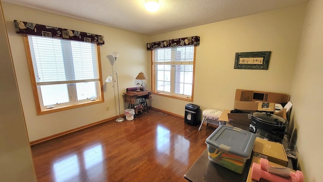 misc room with dark wood-type flooring and a textured ceiling