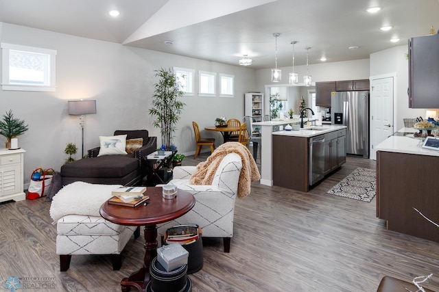 living room featuring vaulted ceiling, sink, and dark wood-type flooring