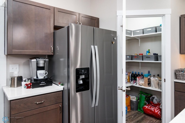 kitchen with dark brown cabinetry, stainless steel fridge, and hardwood / wood-style floors