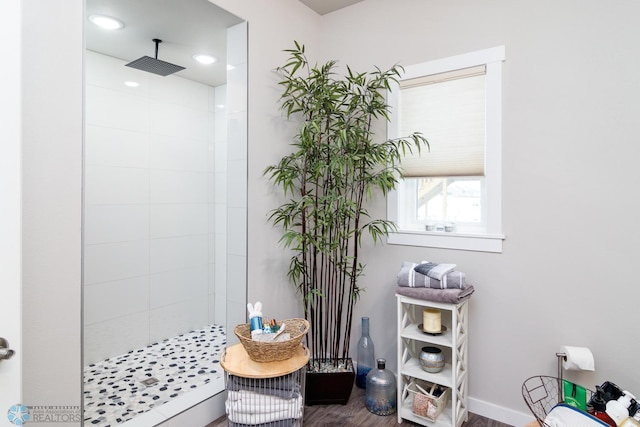 bathroom with hardwood / wood-style flooring and tiled shower