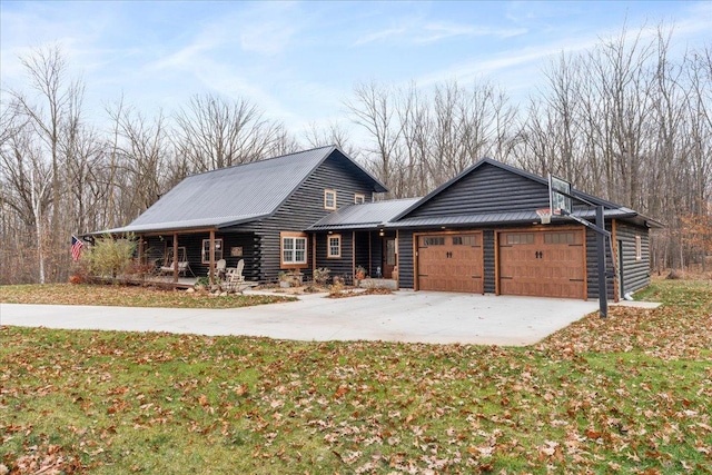 view of front of property with a garage, a front yard, and covered porch