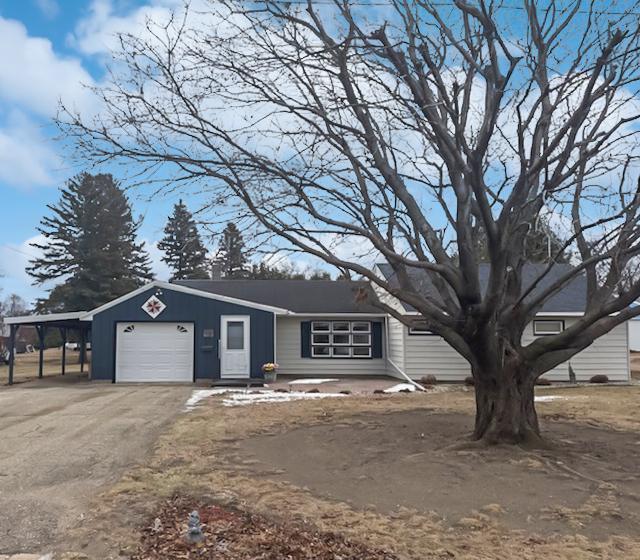 view of front of property featuring a garage and a carport