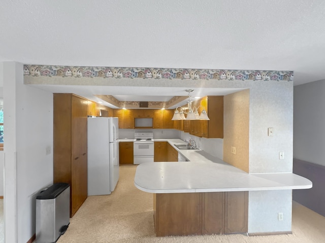 kitchen featuring sink, white appliances, light colored carpet, and kitchen peninsula