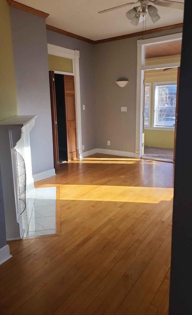 unfurnished room with crown molding, ceiling fan, and light hardwood / wood-style floors