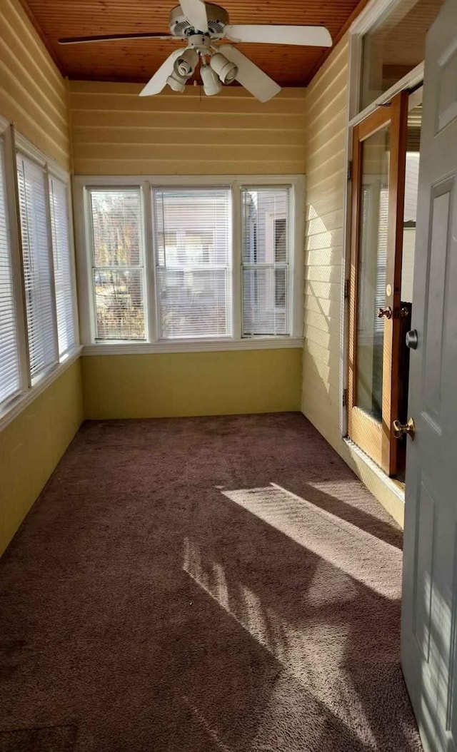 unfurnished sunroom featuring wooden ceiling and ceiling fan